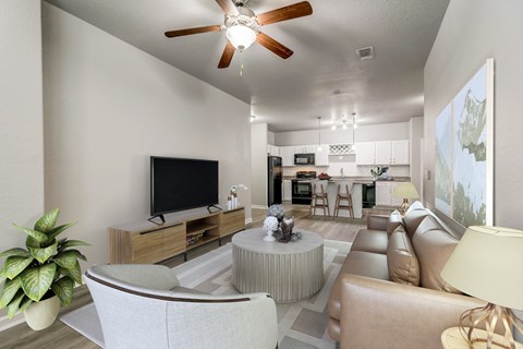 view of living room and kitchen with couches and a table and a ceiling fan